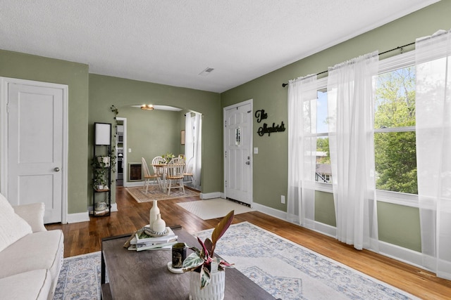 3610 Gleason Dr, Chattanooga, TN 37412 - living room featuring baseboards, arched walkways, a textured ceiling, and wood finished floors