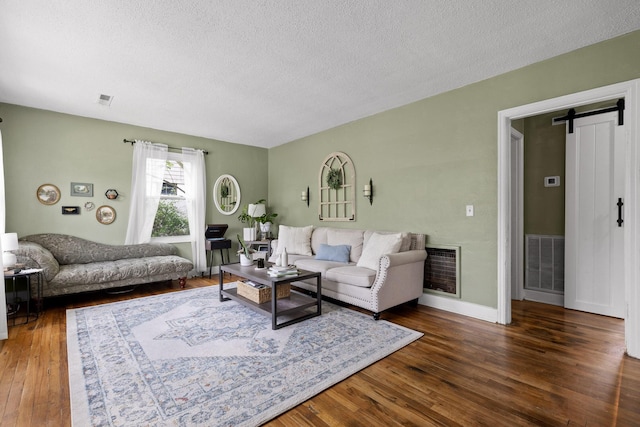 3610 Gleason Dr, Chattanooga, TN 37412 - living room with wood-type flooring, a textured ceiling, visible vents, and a barn door