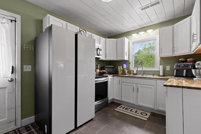 3610 Gleason Dr, Chattanooga, TN 37412 - kitchen featuring electric range, butcher block countertops, white cabinetry, stainless steel microwave, and a sink