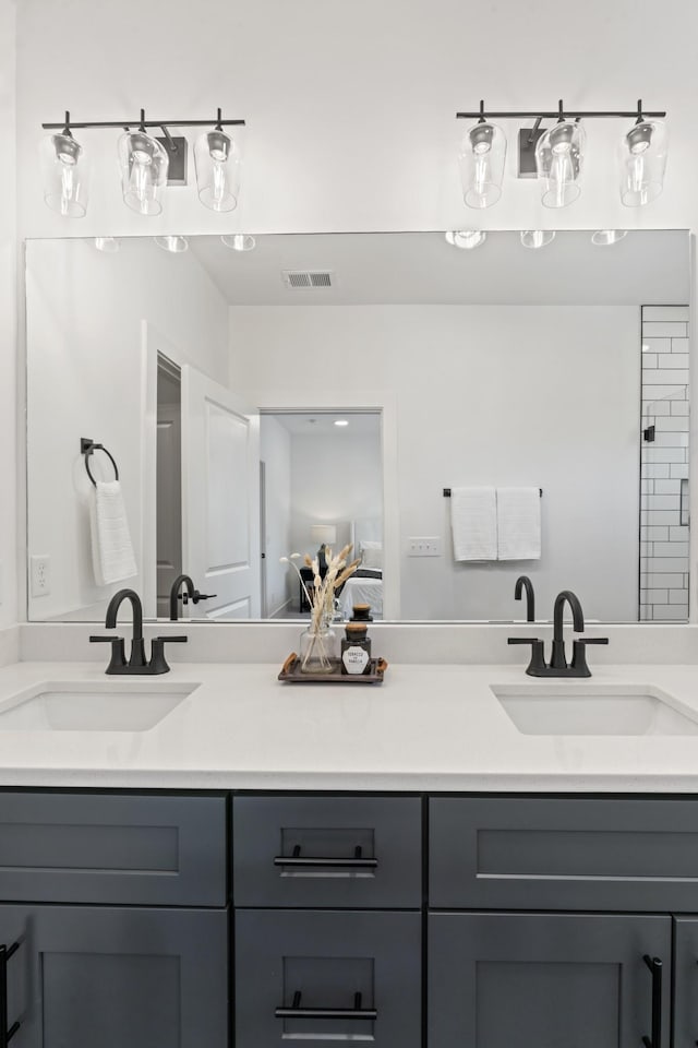bathroom with double vanity, visible vents, and a sink