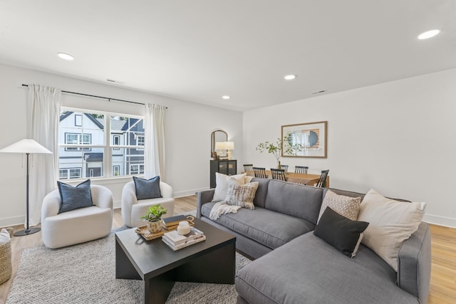 living room featuring recessed lighting, light wood-style flooring, baseboards, and visible vents