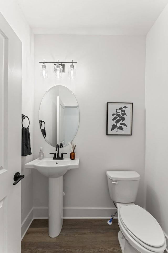 bathroom featuring baseboards, toilet, and wood finished floors