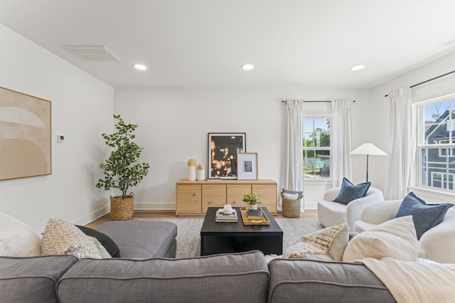 living room featuring visible vents, recessed lighting, baseboards, and wood finished floors