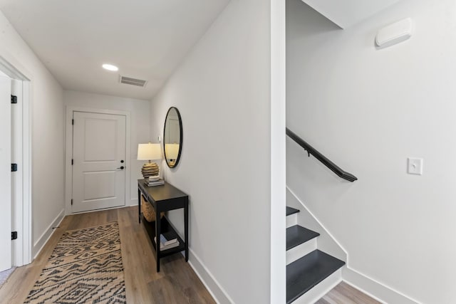interior space with baseboards, wood finished floors, and visible vents