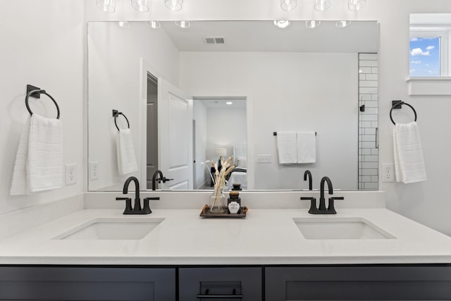 ensuite bathroom featuring double vanity, visible vents, a sink, and ensuite bath
