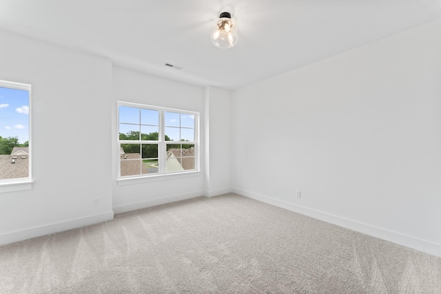 empty room featuring carpet flooring, baseboards, and visible vents