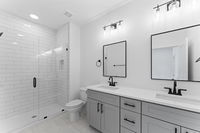full bathroom with double vanity, toilet, a shower stall, and a sink