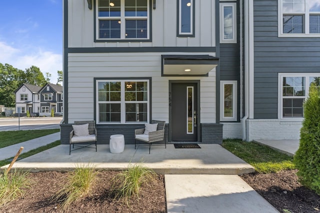 doorway to property featuring brick siding and board and batten siding