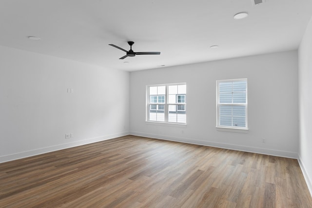 spare room featuring a ceiling fan, baseboards, and wood finished floors