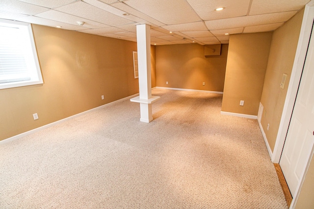 below grade area with carpet flooring, baseboards, and a paneled ceiling