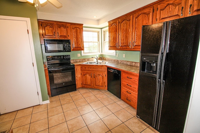 kitchen featuring brown cabinets, a sink, light tile patterned floors, and black appliances