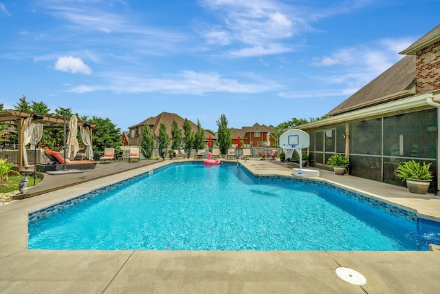 view of swimming pool with a patio, a sunroom, a fenced in pool, and fence