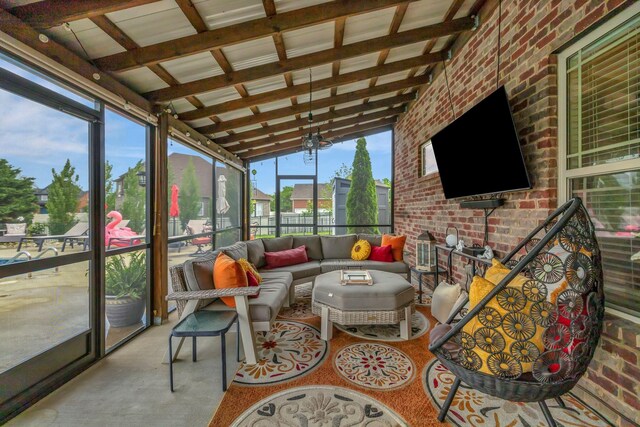 sunroom / solarium featuring an outdoor living space and beam ceiling