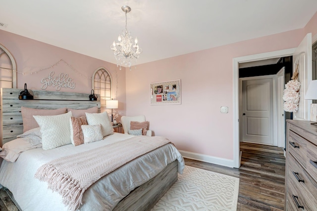 bedroom with baseboards, dark wood-style flooring, and a notable chandelier