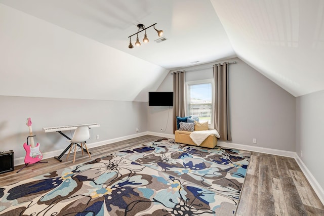 additional living space featuring baseboards, wood finished floors, and vaulted ceiling