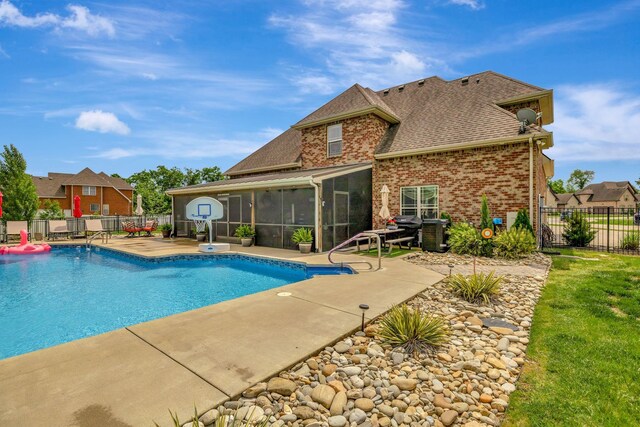 view of swimming pool featuring fence, a fenced in pool, a patio, and a sunroom