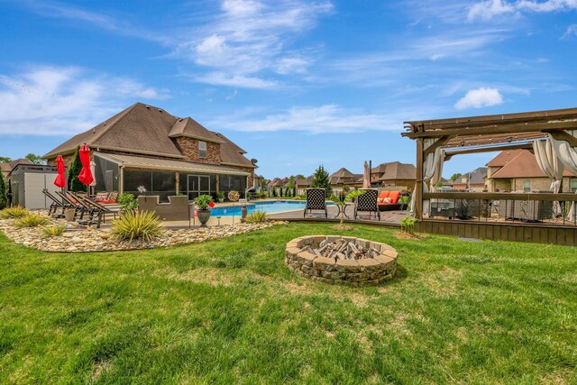 view of yard featuring a patio area, a fire pit, and an outdoor pool