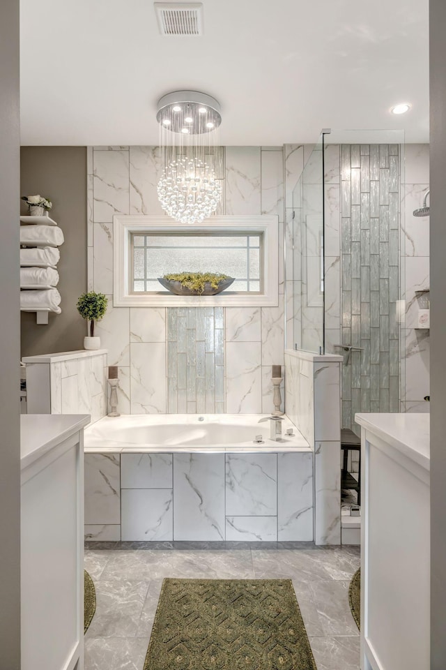 bathroom featuring a bath, a walk in shower, visible vents, and marble finish floor