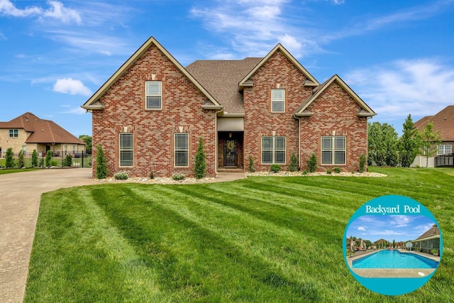view of front of home featuring fence, a shingled roof, a front yard, and brick siding