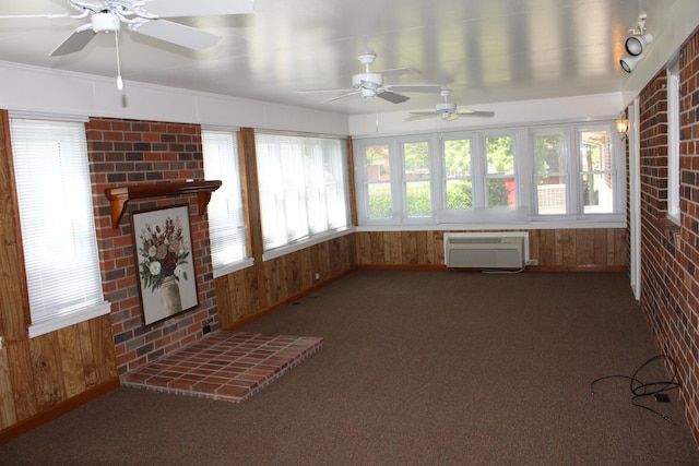 unfurnished sunroom featuring baseboards, a wall mounted AC, carpet flooring, and wood walls