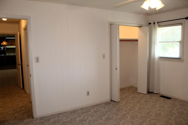 unfurnished bedroom featuring light carpet, a closet, and visible vents