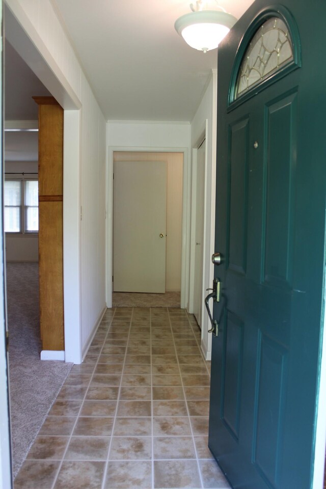 entryway with light colored carpet and light tile patterned floors