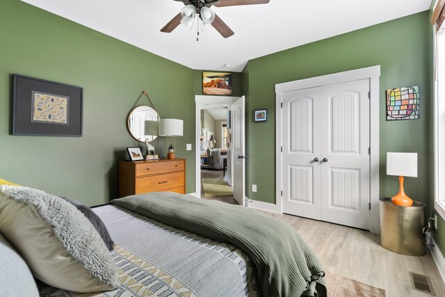 bedroom with a ceiling fan, visible vents, baseboards, a closet, and light wood-style flooring