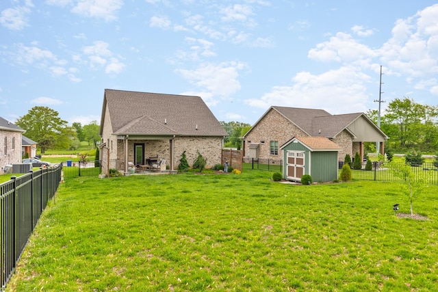 back of house with a storage shed, a patio, a yard, and an outdoor structure