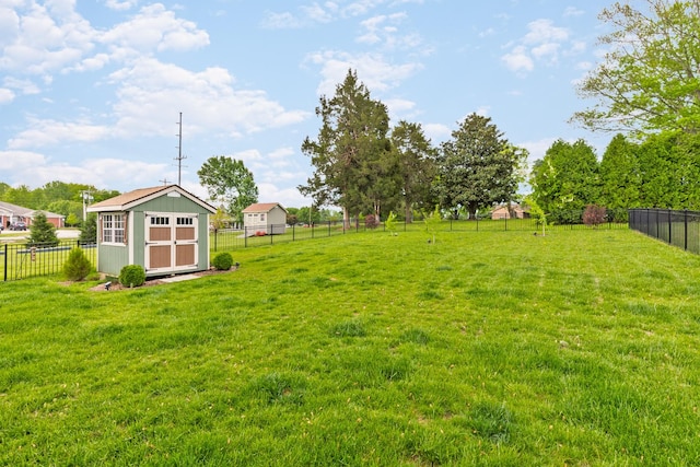 view of yard featuring a fenced backyard, a storage unit, and an outbuilding