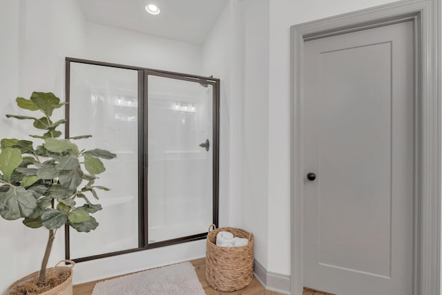 bathroom featuring wood finished floors and a stall shower
