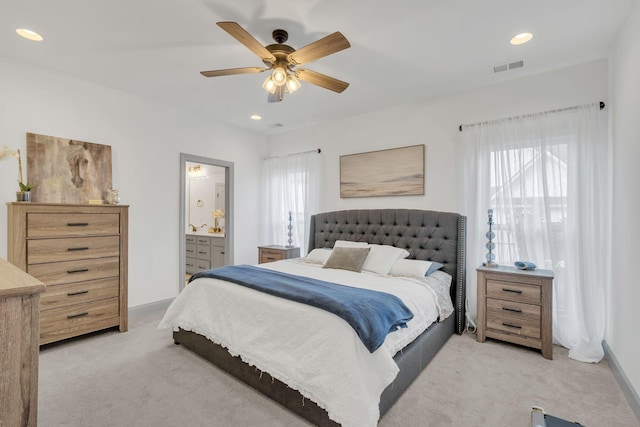 bedroom featuring a ceiling fan, visible vents, ensuite bathroom, light carpet, and recessed lighting