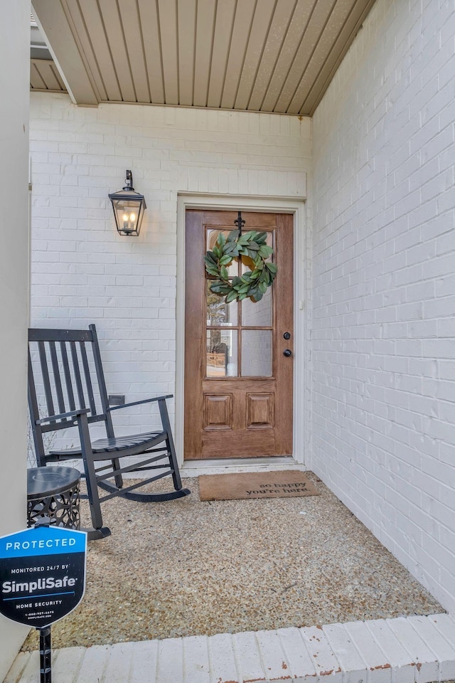 view of exterior entry featuring brick siding