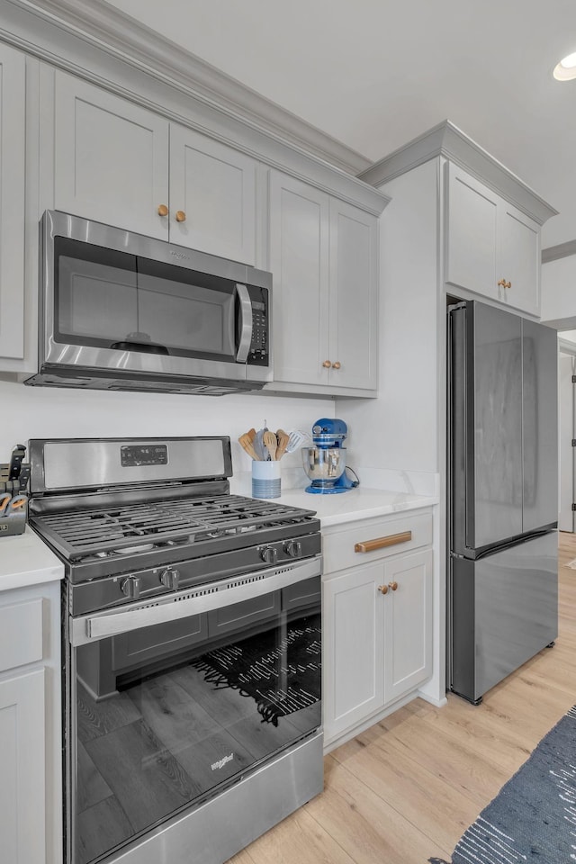 kitchen featuring light countertops, stainless steel appliances, recessed lighting, and light wood-style flooring