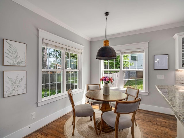 dining room with baseboards, plenty of natural light, ornamental molding, and wood finished floors