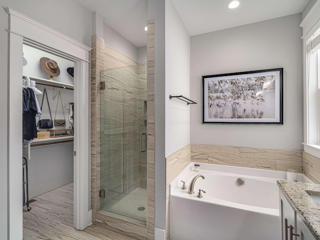 bathroom with a bath, a stall shower, vanity, a spacious closet, and recessed lighting