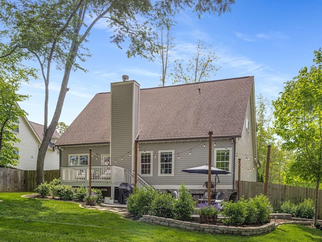 back of house featuring fence, a yard, and a wooden deck