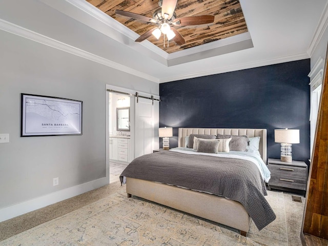 bedroom with baseboards, a barn door, a raised ceiling, and ornamental molding
