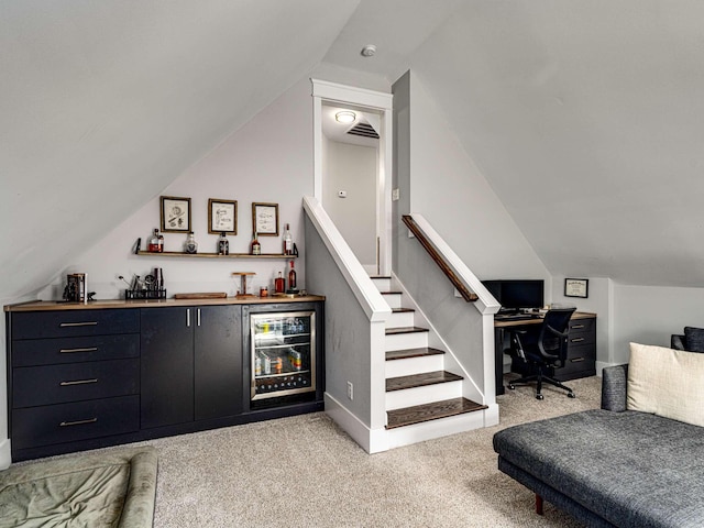 bar featuring visible vents, lofted ceiling, light carpet, beverage cooler, and a bar