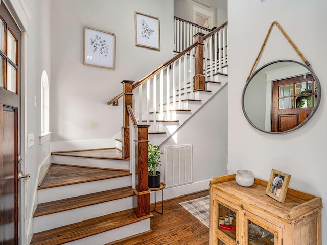 staircase featuring visible vents, plenty of natural light, and wood finished floors