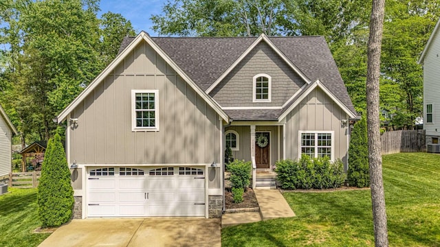 view of front of property with concrete driveway, a front yard, fence, and roof with shingles