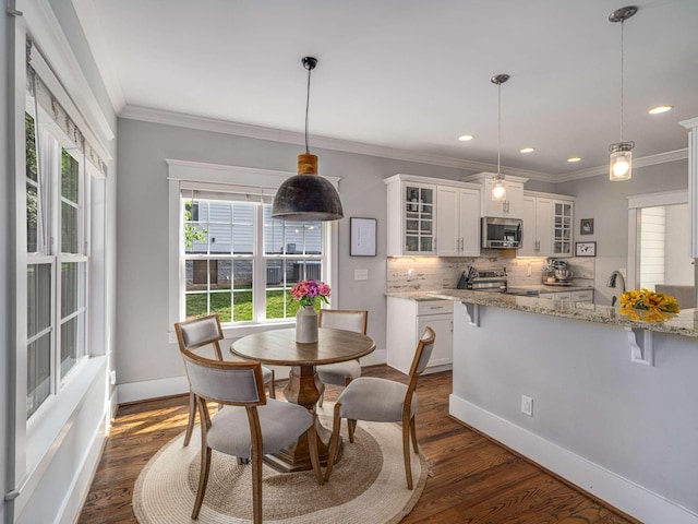 dining space with crown molding, dark wood-style flooring, baseboards, and recessed lighting