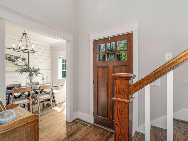 entryway with an inviting chandelier, baseboards, stairway, and wood finished floors