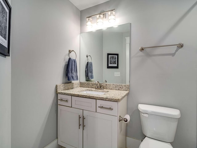 half bathroom featuring vanity and toilet
