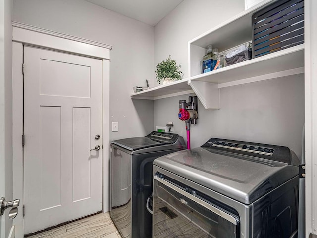 laundry room featuring laundry area, washer and dryer, and light wood-type flooring