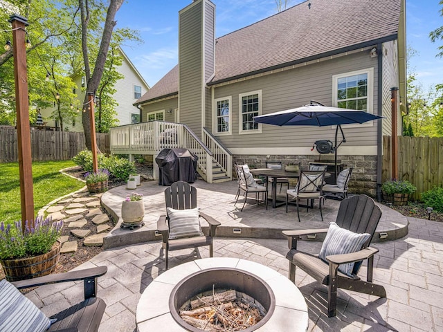 view of patio / terrace with a fire pit, fence, grilling area, and a wooden deck