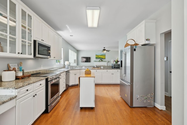 104 Drayton Ct, Franklin, TN 37067 - kitchen featuring a peninsula, glass insert cabinets, white cabinets, a ceiling fan, and stainless steel appliances