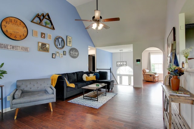 living room with arched walkways, high vaulted ceiling, wood finished floors, and ceiling fan with notable chandelier