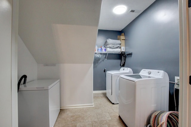 washroom featuring washer and dryer, light tile patterned flooring, laundry area, baseboards, and visible vents