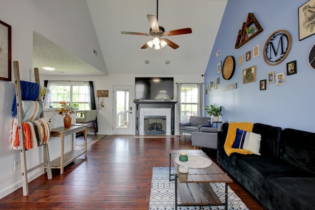 living area featuring visible vents, wood finished floors, ceiling fan, high vaulted ceiling, and a tiled fireplace