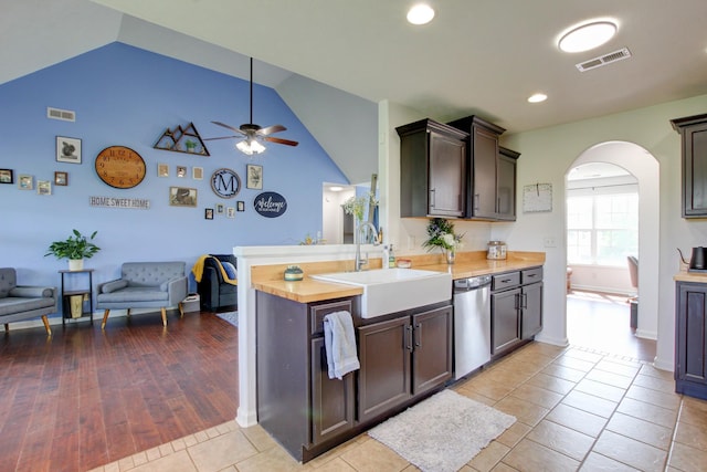 kitchen with a sink, arched walkways, a ceiling fan, stainless steel dishwasher, and visible vents